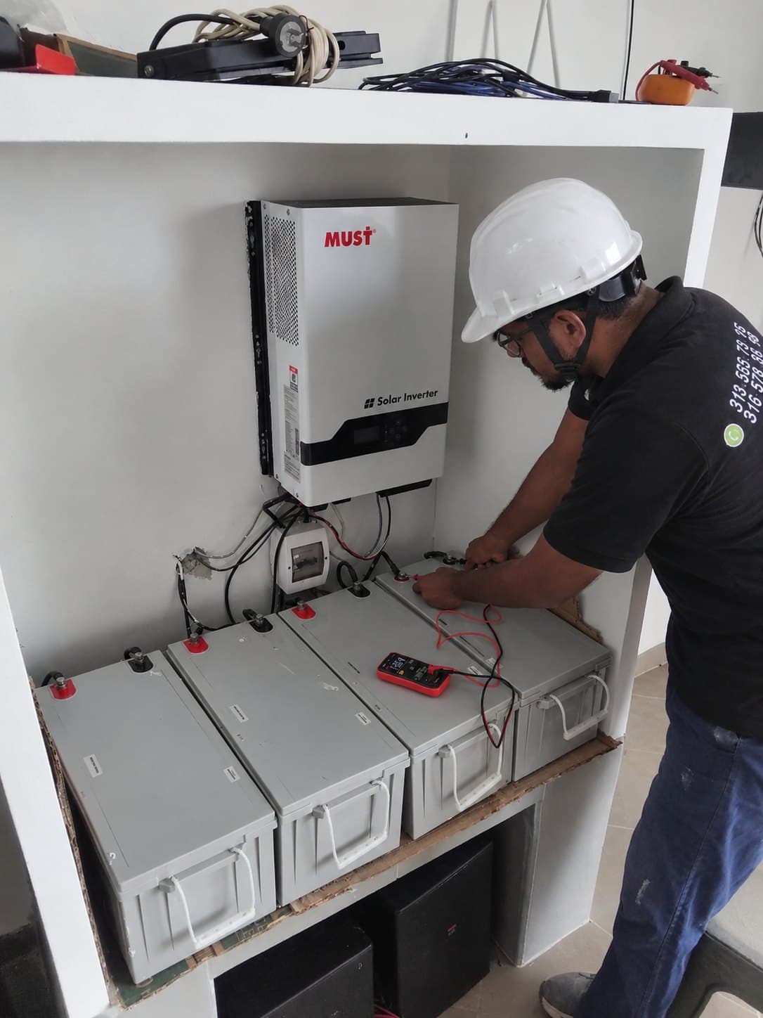 Técnico midiendo un banco de baterías conectado a un inversor